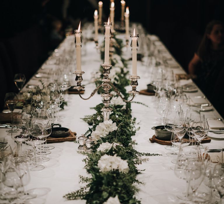 Wedding centrepiece with candelabras and greenery runner