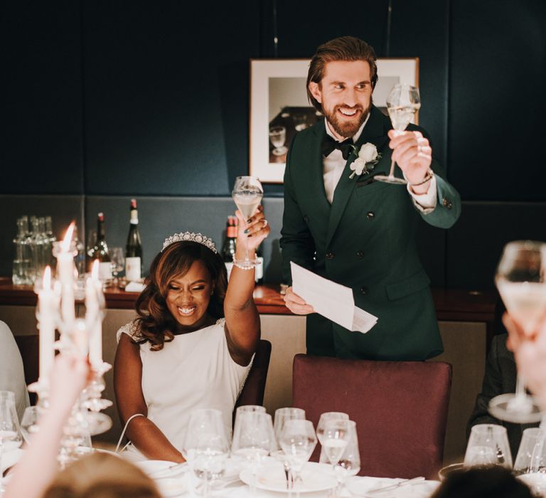 Bride and groom raising a glass at intimate wedding reception