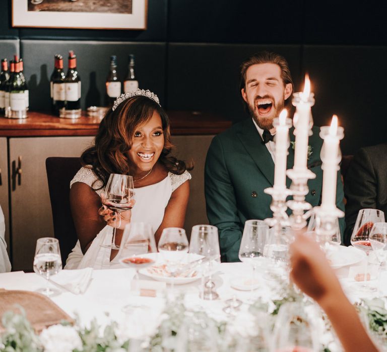 Bride and groom laughing during wedding speeches