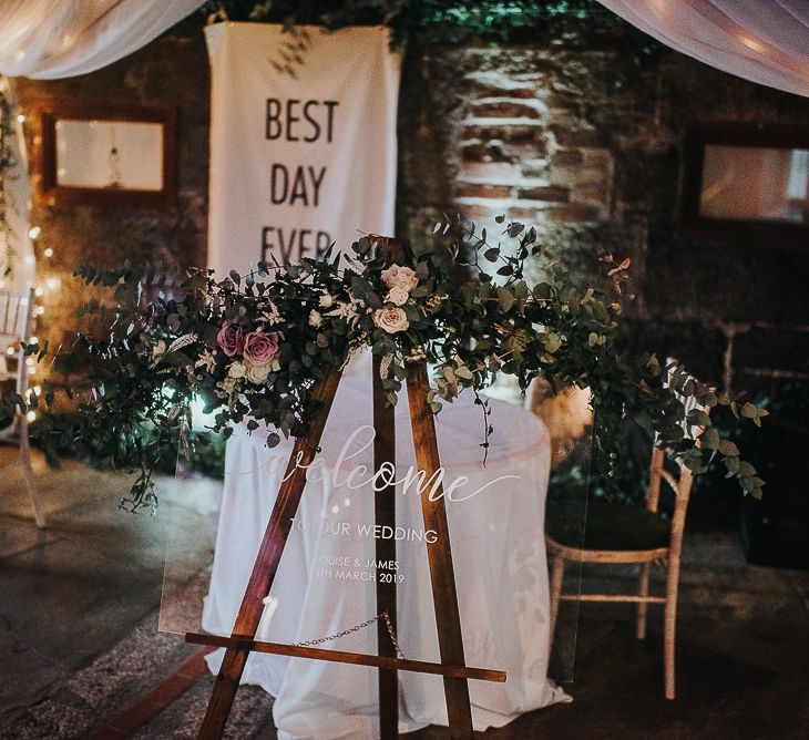 Acrylic Wedding Sign Resting on an Easel with Floral Garland