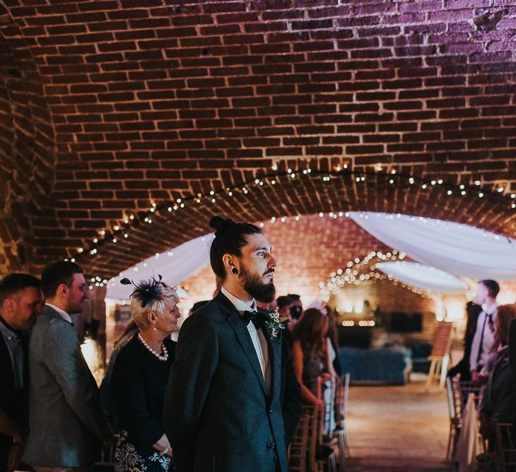 Groom in Bow Tie and Top Knot Standing at the Altar