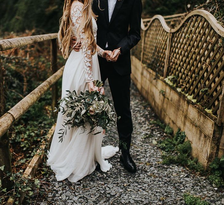 Bride in Catherine Deane Separates with Long Sleeves Holding a Wildflower Bouquet