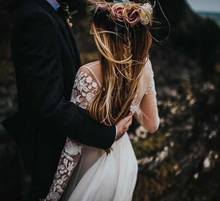 Groom Embracing His Bride with Half Up Half Down Hair Style in Flower Crown