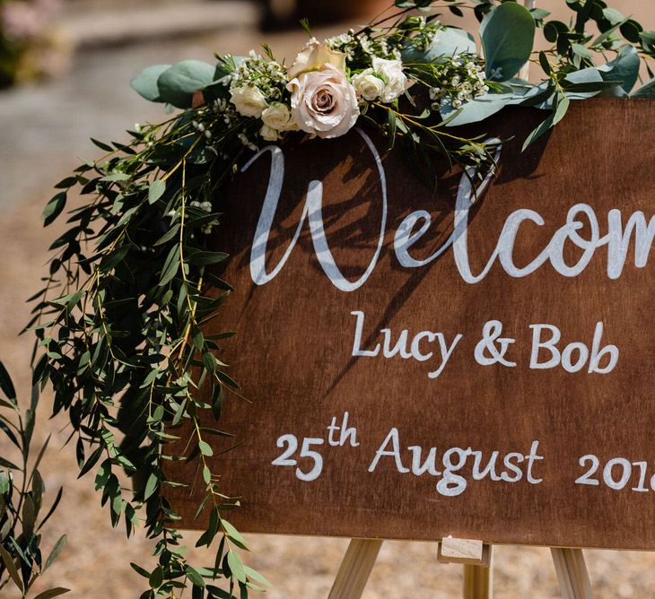 Wooden Wedding Welcome Sign with White Calligraphy Writing and Flower Decor