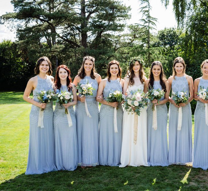 Bridal Party with Bridesmaids in Blue Monsoon Dress and Bride in Charlie Brear Wedding Dress Holding Pastel Flower Bouquets