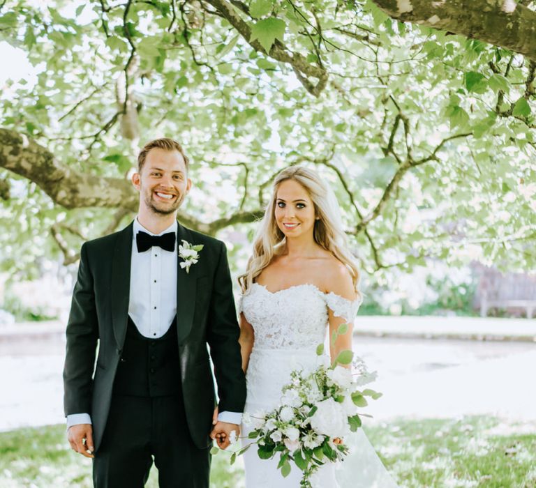 Bride in Lace St Partrick Wedding Dress with Groom in Black Tuxedo Suit