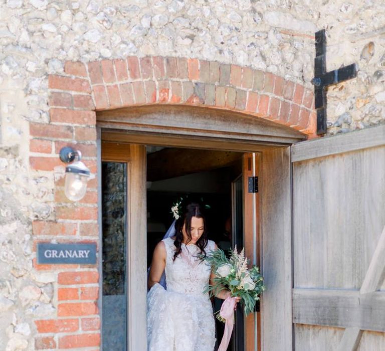 Bride makes her way to wedding ceremony carrying gorgeous bouquet