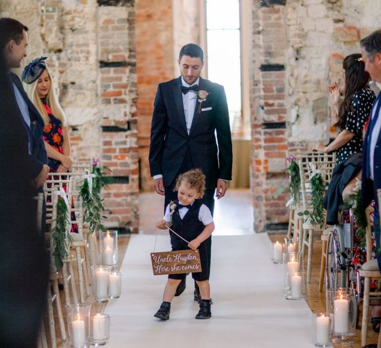 Cute page boy with wedding sign