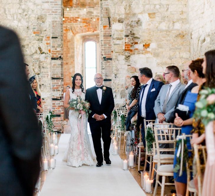 Bride walks down the aisle at Lulworth Castle wedding