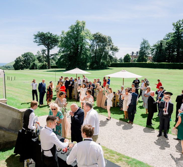 Guests enjoy drinks on the lawns of Lulworth Castle