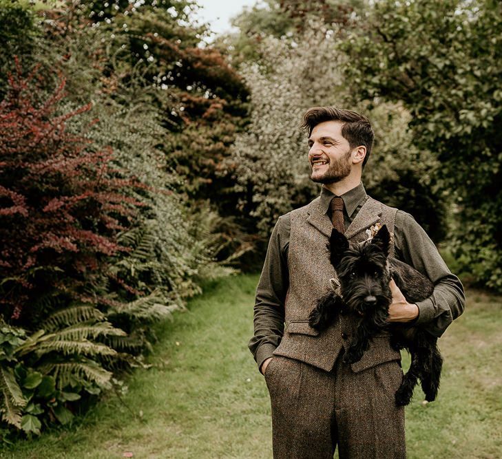 Groom in tweed waistcoat with pet dog for September wedding