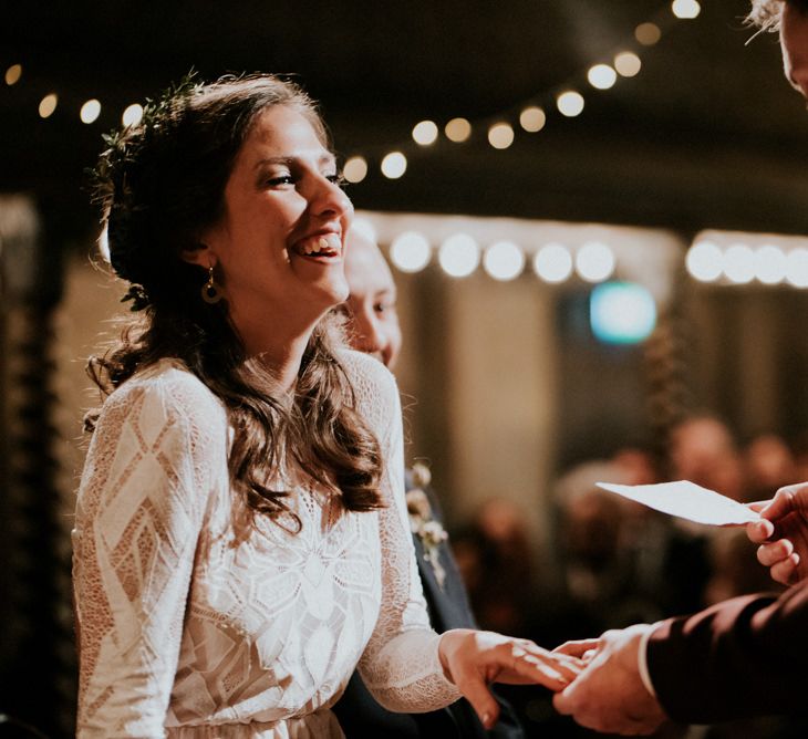 Bride in Grace Loves Lace Wedding Dress with Long Sleeves Laughing During Wedding Ceremony