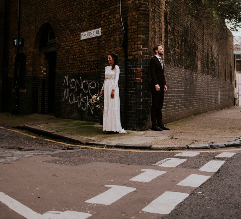 Urban Portrait of Bride in Grace Loves Lace Wedding Dress and Groom in Dark Suit on the Edge of a Corner