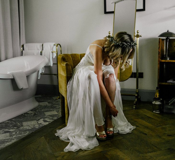 Bride putting on her gold platforms on wedding morning