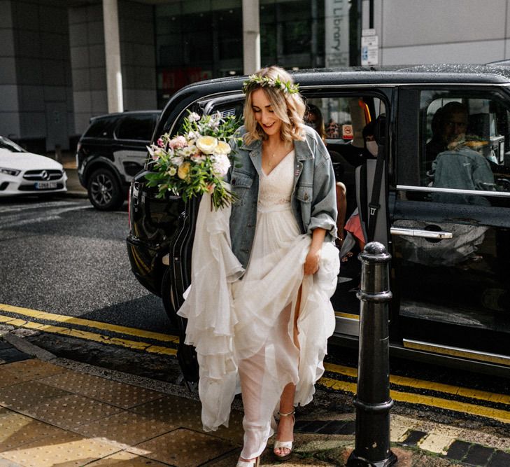 Bride arriving at Hackney Town Hall wedding in Catherine Deane wedding dress and denim jacket