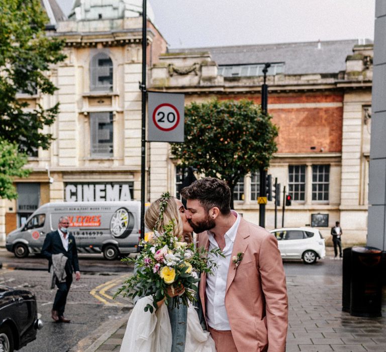 Bride and groom kissing outside Hackney Town Hall