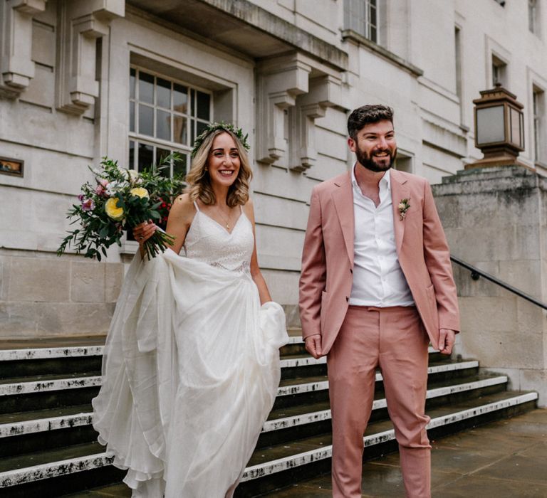 Bride and groom on the steps at their Hackney Town Hall intimate wedding