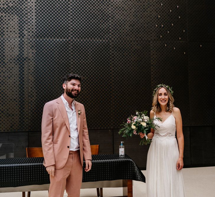 Stylish bride and groom at the altar of their Hackney Tow Hall wedding