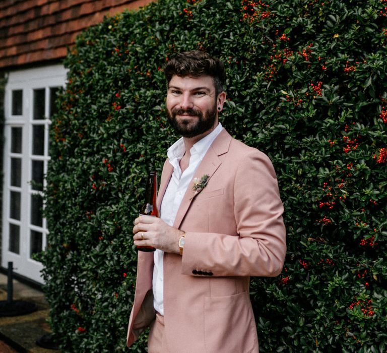 Groom in pink wedding suit at Micro wedding