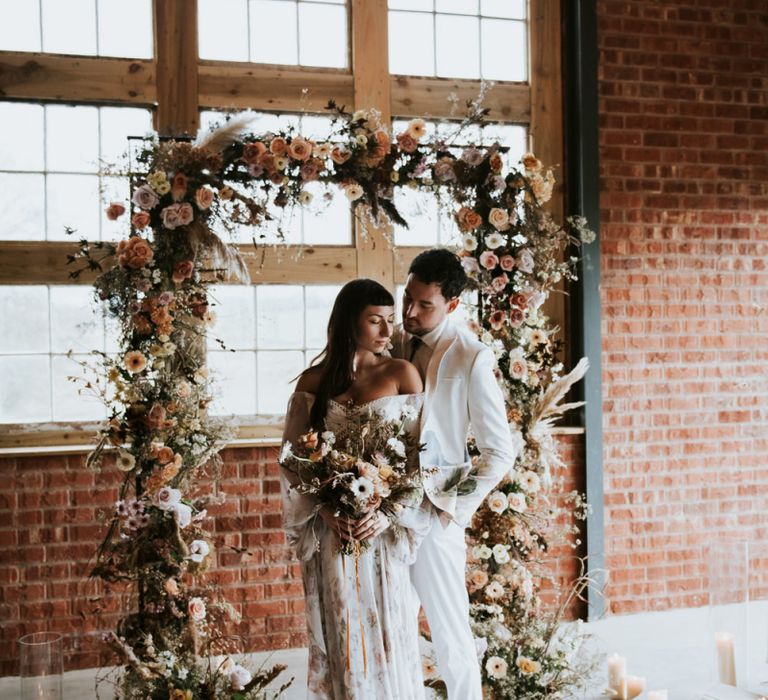 Bride and Groom Portrait in front of Dried Flowers Arch