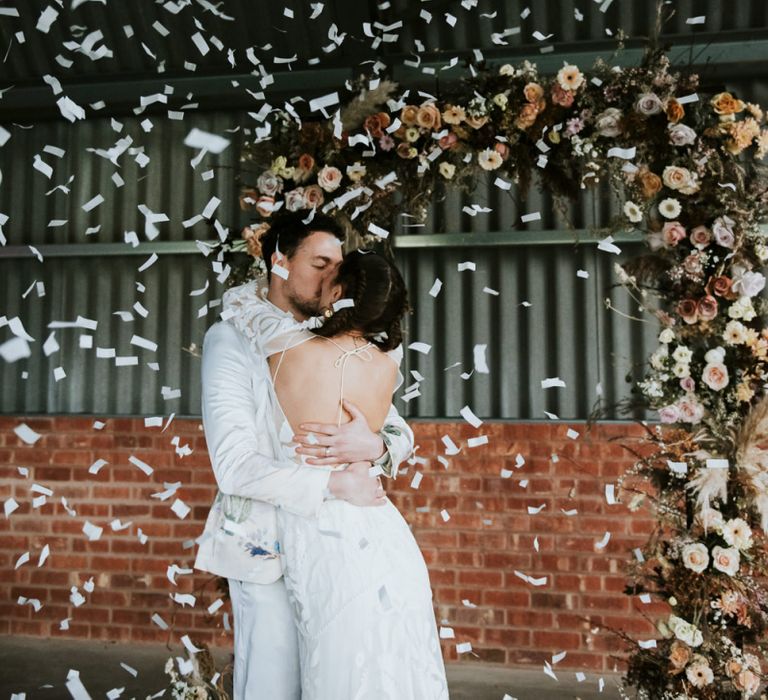 Bride and Groom Kissing Whilst Confetti Cannon Goes Off