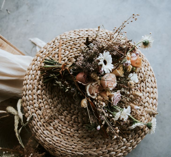 Wicker Chair with Peach, White and Dried Flowers Mixed in the Bouquet