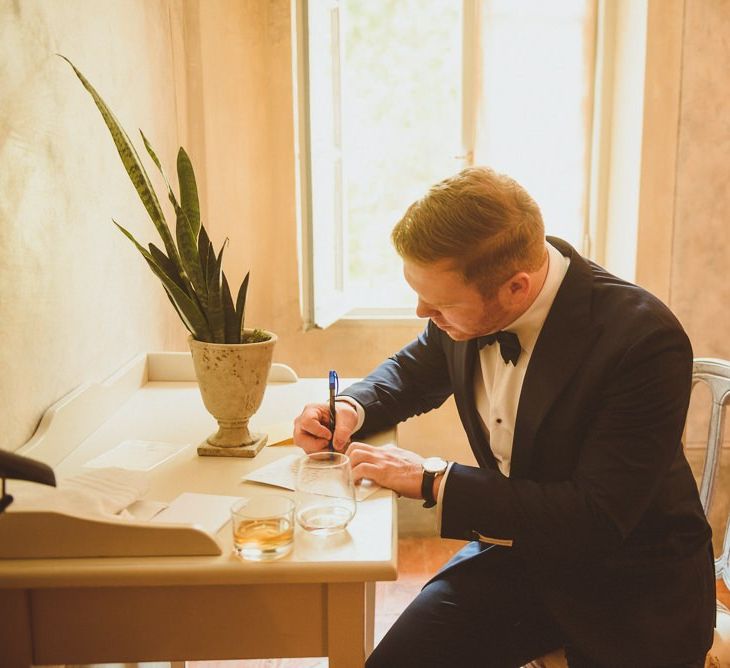 Groom on wedding morning writing a love note