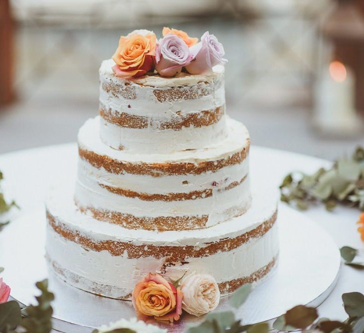 Semi naked wedding cake decorated with fresh flowers