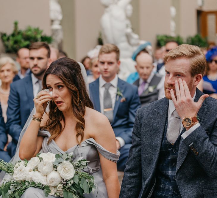 Emotional Bride  in Tulle Custom Made Blue Claire La Faye Wedding Dress and Groom in Bespoke Alton Lane Suit During Orangery Wedding Ceremony