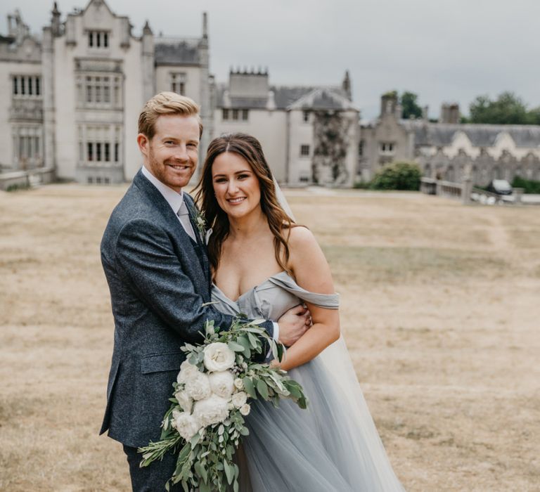 Bride in Custom Made Claire La Faye Wedding Dress and Groom in Bespoke Alton Lane Suit Embracing