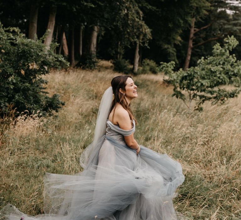 Bride in Custom Made Blue Claire La Faye Wedding Dress Twirling in the Grass