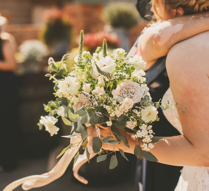 White wedding bouquet for bride in Pronovias strapless wedding dress