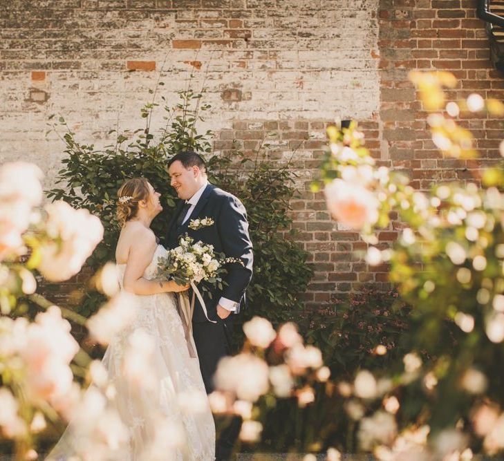 Bride with groom in navy wedding suit