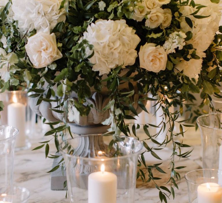 White wedding flowers and candles in hurricane vases