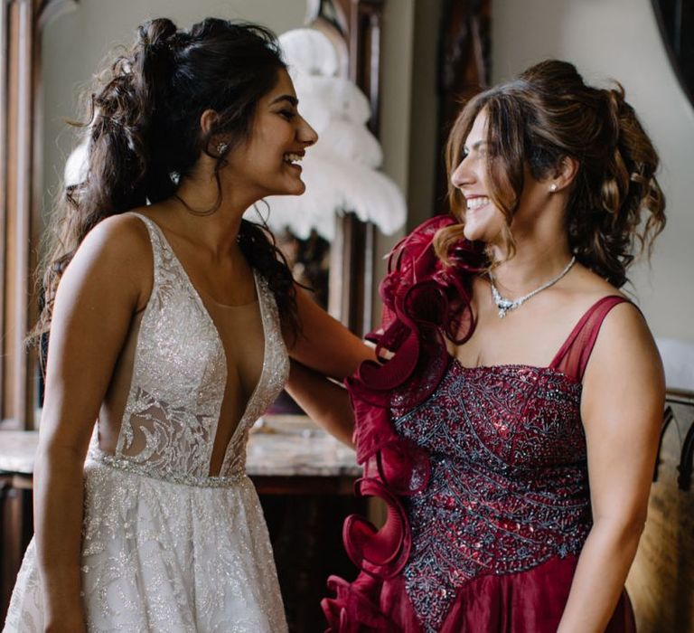 Bride in Berta Bridal gown with friend in red ball gown