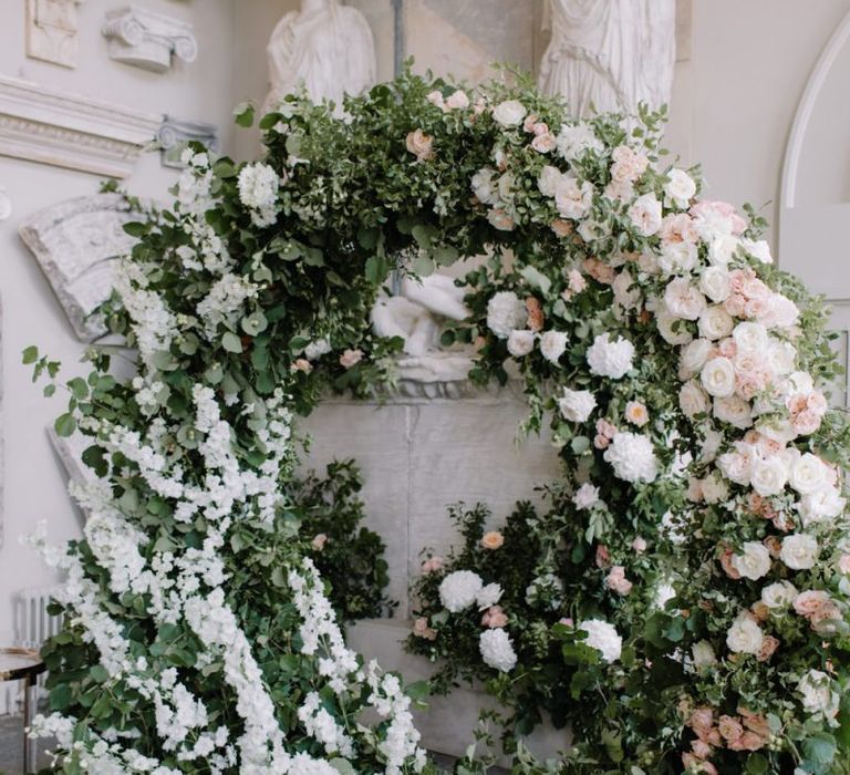 Green, white and pink floral moon gate at Aynhoe Park