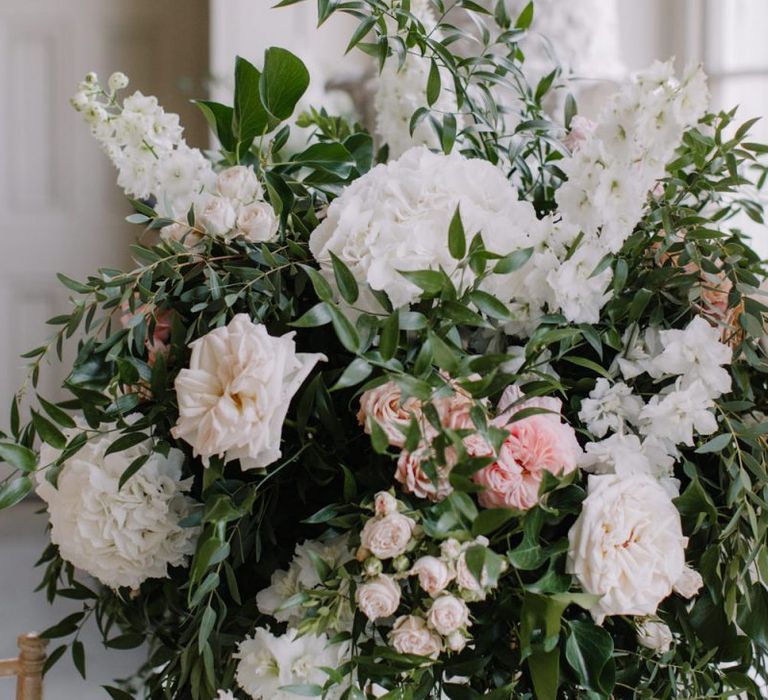 White and pink wedding flower arrangements with foliage