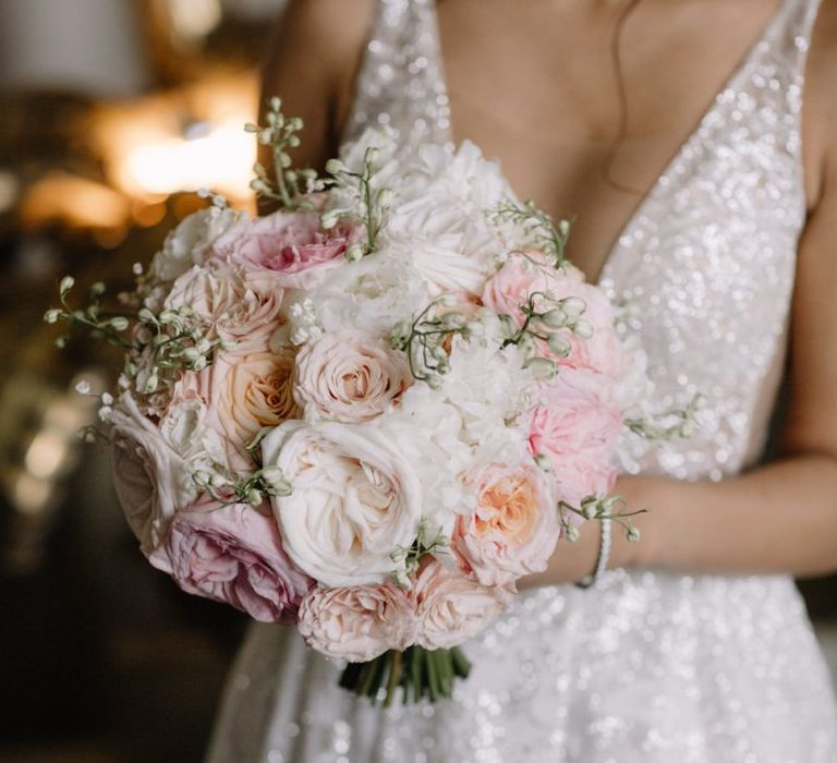 Bride in Berta Bridal gown holding a romantic blush pink and white wedding bouquet with David Austin roses