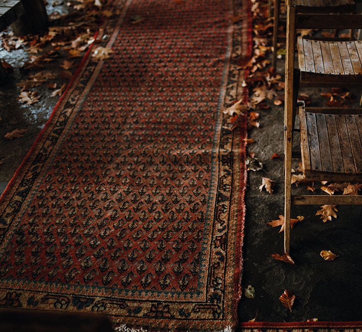 Persian Rugs and Autumn Leaves Lining Aisle | Rustic Wooden Chairs | Mariachi Band and Persian Rug Aisle for Autumn Wedding | Leah Lombardi Weddings