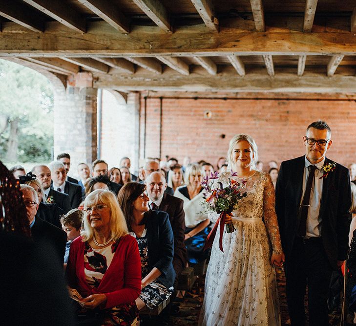 Bride in Bead Embellished Needle &amp; Thread Gown with Cascading Tulle Skirt and Semi-Sheer Sleeves | Purple, Orange and Pink Flowers with Foliage and Maroon Trailing Ribbon | Entrance of the Bride | Mariachi Band and Persian Rug Aisle for Autumn Wedding | Leah Lombardi Weddings