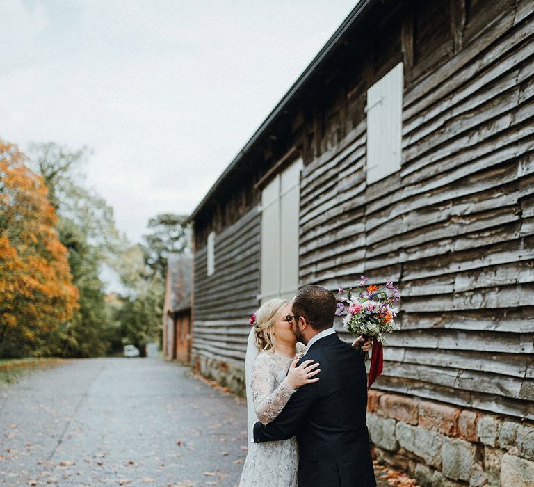 Bride in Bead Embellished Needle &amp; Thread Gown with Cascading Tulle Skirt and Semi-Sheer Sleeves | Elbow Length Veil | Bridal Up Do with Pink Hair Flowers | Groom in Check Blue Three-Piece Suit by T.M.Lewin with Maroon Tie and Pocket Square | Purple, Orange and Pink Flowers with Foliage and Maroon Trailing Ribbon | Pimhill Barn Wedding Venue | Mariachi Band and Persian Rug Aisle for Autumn Wedding | Leah Lombardi Weddings