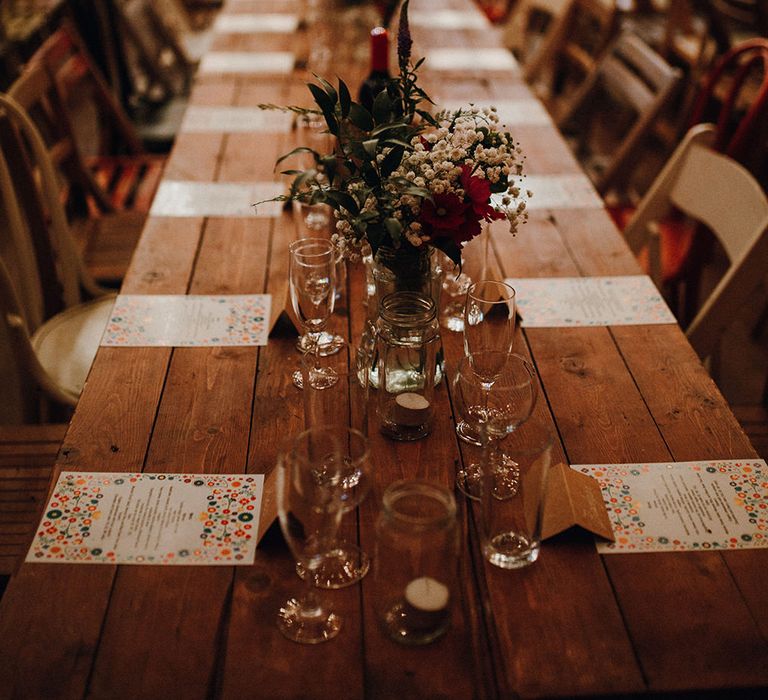 Wooden Banquet Tables | Mismatched Rustic Chairs | Tea Lights in Jars | Kraft Place Settings | Wedding Breakfast Menus | Red and White Flowers and Foliage Centrepieces | Mariachi Band and Persian Rug Aisle for Autumn Wedding | Leah Lombardi Weddings