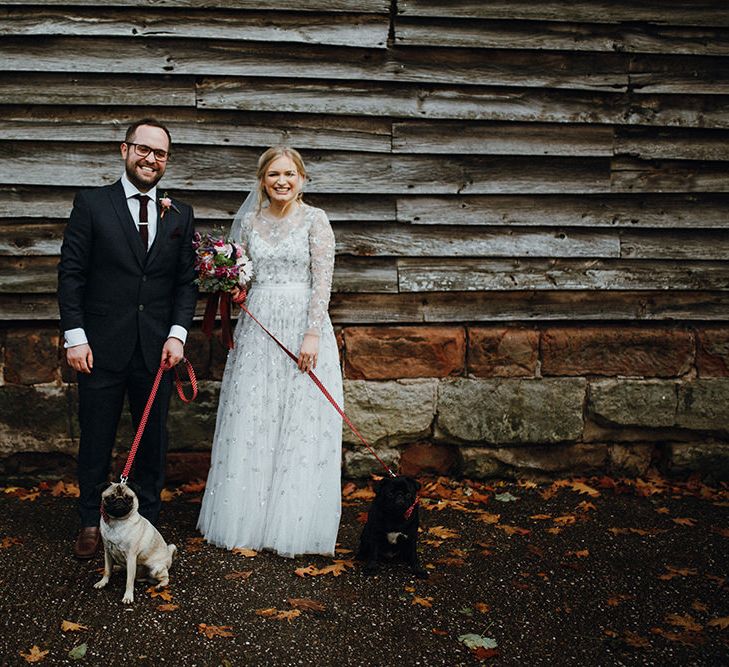 Bride in Bead Embellished Needle &amp; Thread Gown with Cascading Tulle Skirt and Semi-Sheer Sleeves | Elbow Length Veil | Bridal Up Do with Pink Hair Flowers | Groom in Check Blue Three-Piece Suit by T.M.Lewin with Maroon Tie and Pocket Square | Purple, Orange and Pink Flowers with Foliage and Maroon Trailing Ribbon | Pet Pugs Baxter and Bertie | Mariachi Band and Persian Rug Aisle for Autumn Wedding | Leah Lombardi Weddings