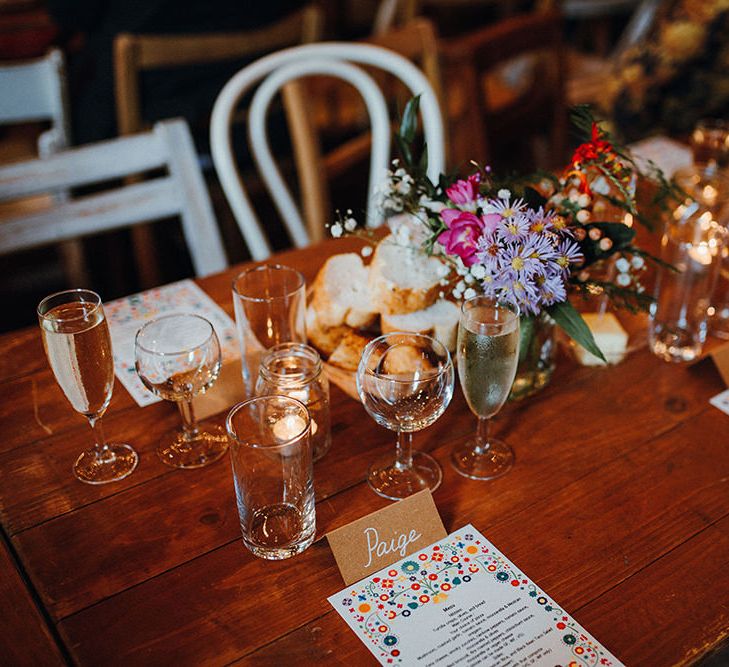 Wooden Banquet Tables | Mismatched Rustic Chairs | Tea Lights in Jars | Kraft Place Settings | Wedding Breakfast Menus | Purple and Pink Table Flowers | Mariachi Band and Persian Rug Aisle for Autumn Wedding | Leah Lombardi Weddings