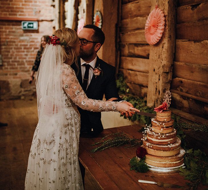 Bride in Bead Embellished Needle &amp; Thread Gown with Cascading Tulle Skirt and Semi-Sheer Sleeves | Elbow Length Veil | Bridal Up Do with Pink Hair Flowers | Groom in Check Blue Three-Piece Suit by T.M.Lewin with Maroon Tie and Pocket Square | Naked Wedding Cake from Waitrose | Wooden Mr and Mrs Cake Topper | Paper Fans | Cutting of the Cake | Mariachi Band and Persian Rug Aisle for Autumn Wedding | Leah Lombardi Weddings