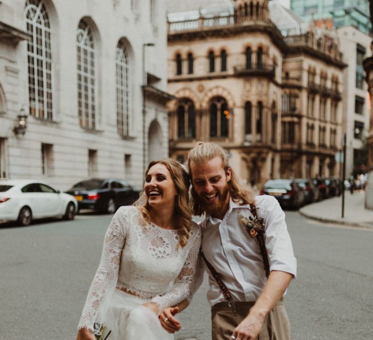 Bride in Separates and Groom in Chinos and Braces Holding Hands Walking Through Manchester Streets