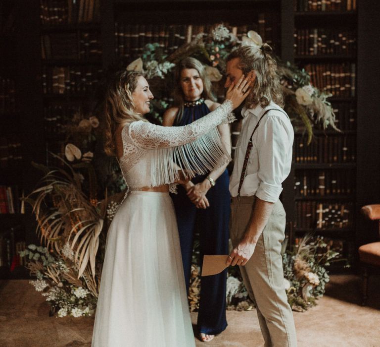 Elopement Wedding Ceremony with Bride in Fringe Sleeve Top Holding Her Grooms Face