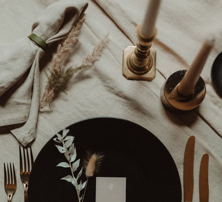 Contemporary Place Setting with Black Tableware and Gold Cutlery