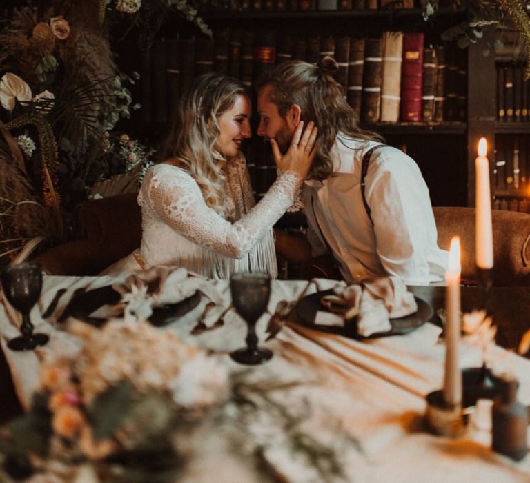 Boho Bride and Groom Embracing at their Sweetheart Table