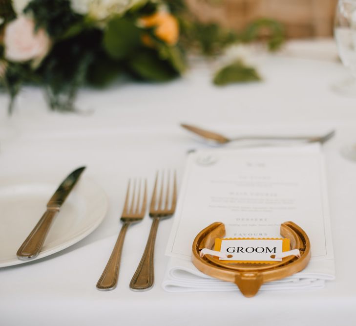 Horseshoe place settings sprayed in gold at marquee reception in Wales